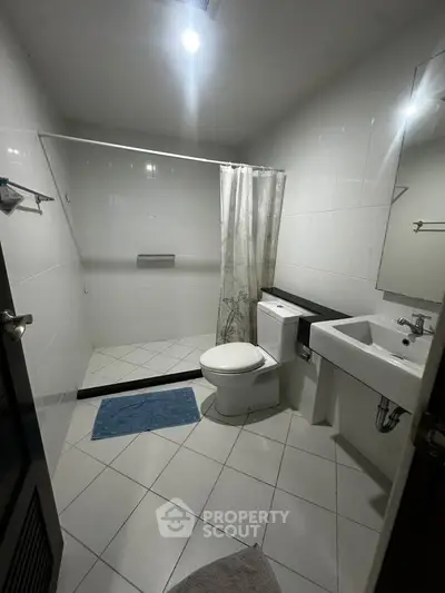 Modern bathroom with sleek design, featuring a spacious shower and elegant fixtures.