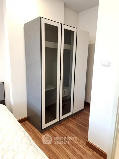 Modern bedroom with stylish wardrobe and wooden flooring