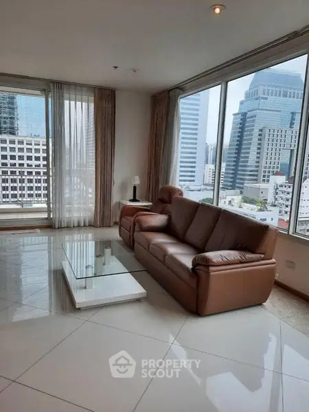 Spacious living room with city view, featuring modern leather sofa and sleek coffee table.