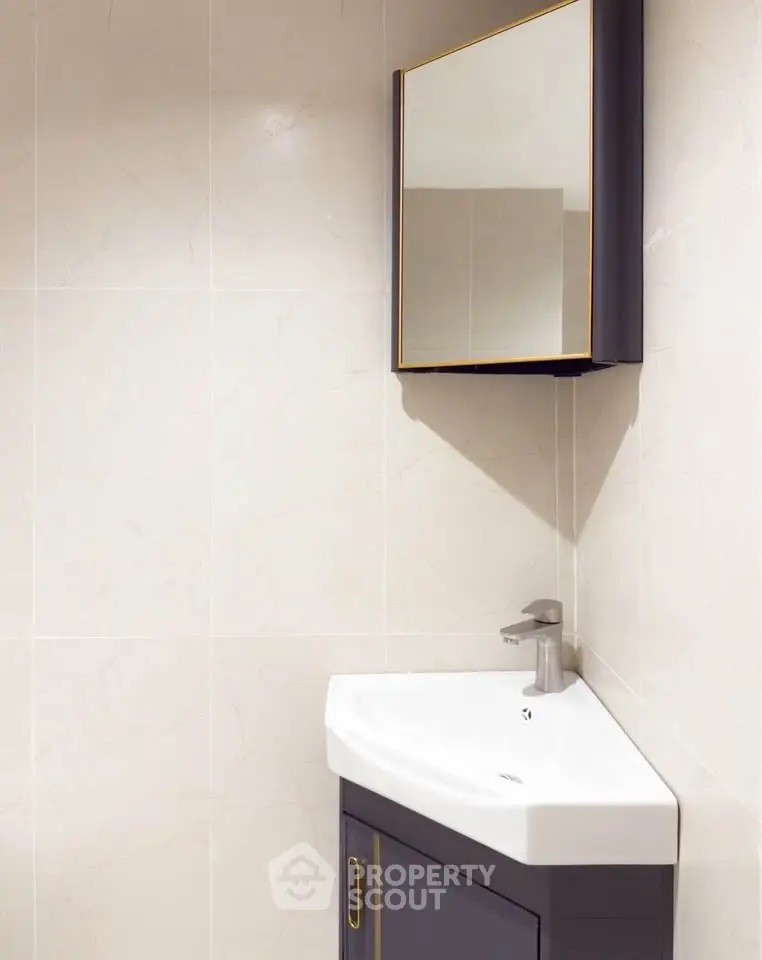 Modern bathroom with sleek corner sink and mirrored cabinet