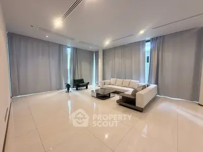Spacious modern living room with elegant furniture and large windows, perfect for relaxation and entertainment.