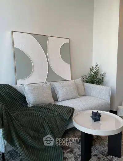 Modern living room with stylish sofa, abstract art, and cozy decor