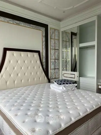 Luxurious bedroom with elegant headboard and plush mattress in modern apartment.