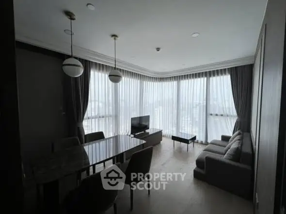 Spacious modern living room with large windows and elegant furnishings.