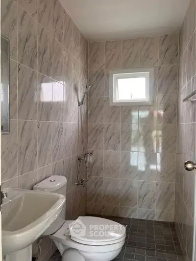 Modern bathroom with tiled walls and compact design