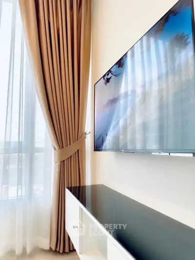Modern living room with sleek wall-mounted TV and elegant curtains