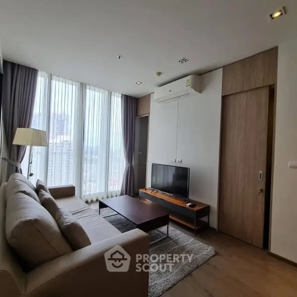 Modern living room with large windows and cozy furniture