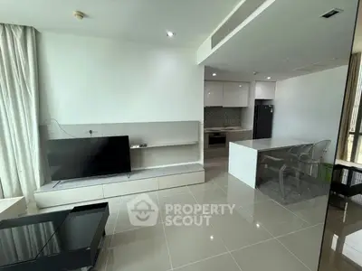 Modern open-plan living room with sleek kitchen and large TV setup