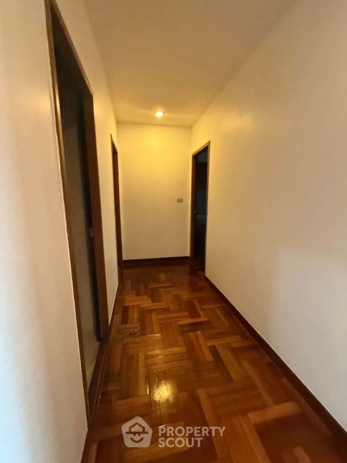 Spacious hallway with polished wooden flooring and ambient lighting