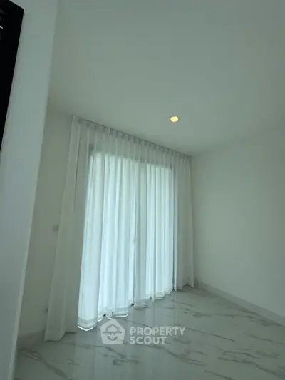 Bright empty room with elegant marble flooring and sheer curtains