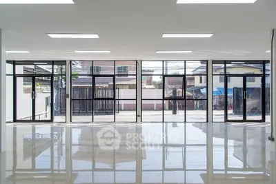 Spacious modern interior with large glass windows and polished floors, ideal for commercial use.