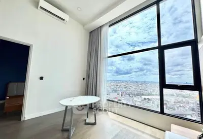 Modern living room with large window offering stunning city view, featuring minimalist decor and air conditioning.