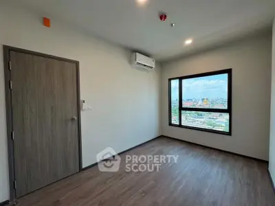 Spacious empty room with large window offering stunning city view, perfect for customization.