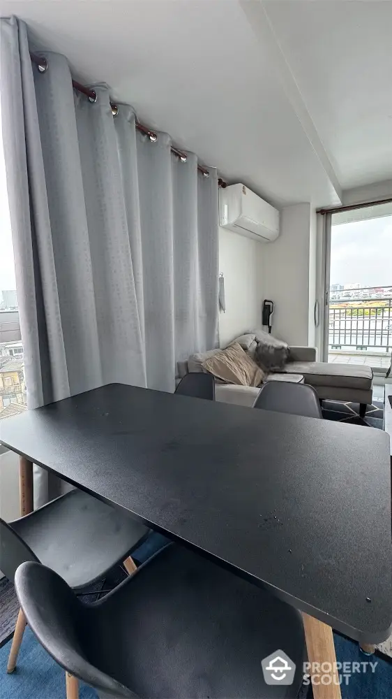 Modern living room with sleek black dining table and city view