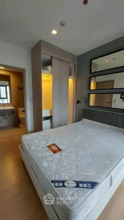 Modern bedroom with large mirror and cozy lighting