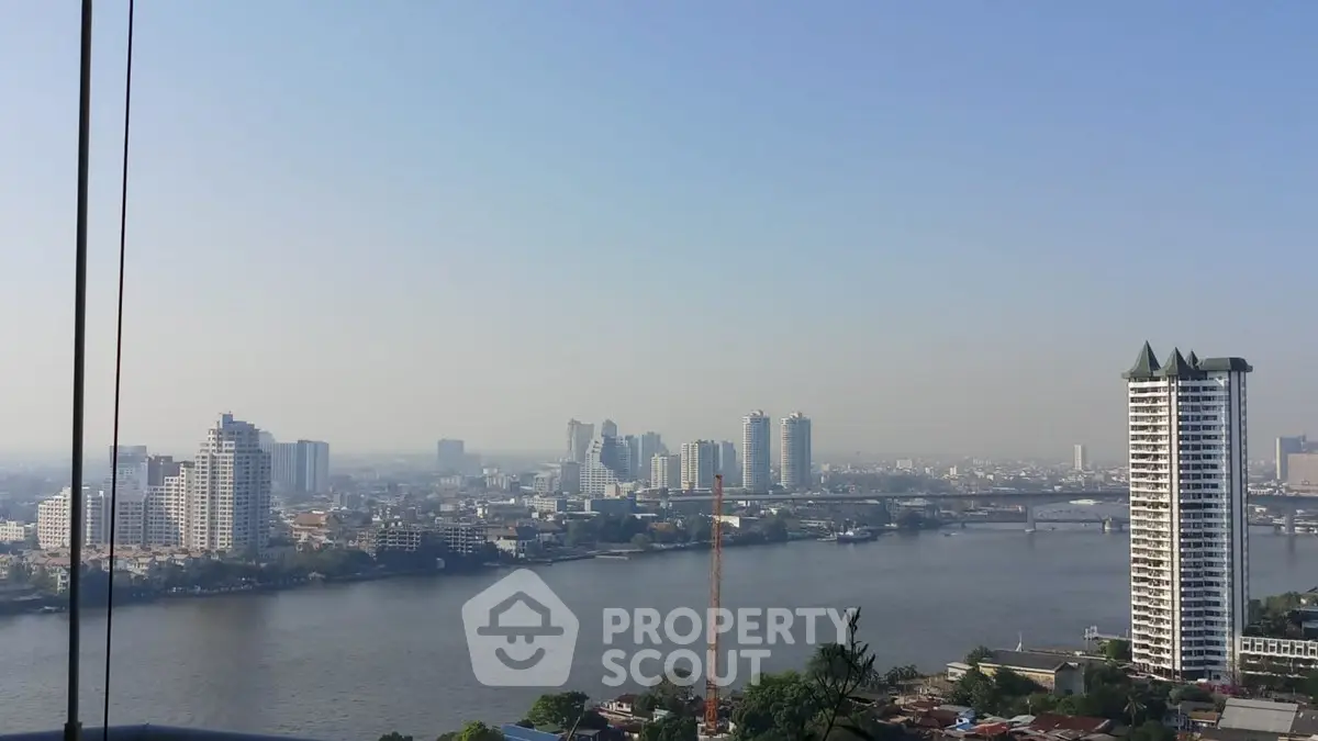 Stunning cityscape view from high-rise building overlooking river and skyline.