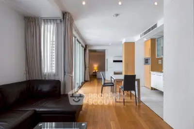 Spacious modern living room with open kitchen and elegant wooden flooring.