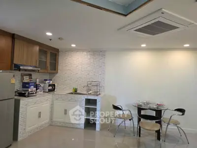 Modern kitchen with sleek cabinetry and dining area in open layout apartment.