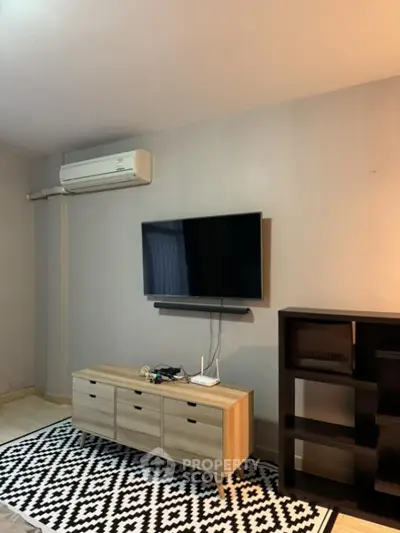 Modern living room with wall-mounted TV and stylish furniture