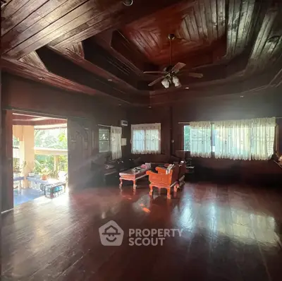 Spacious wooden living room with high ceiling and natural light