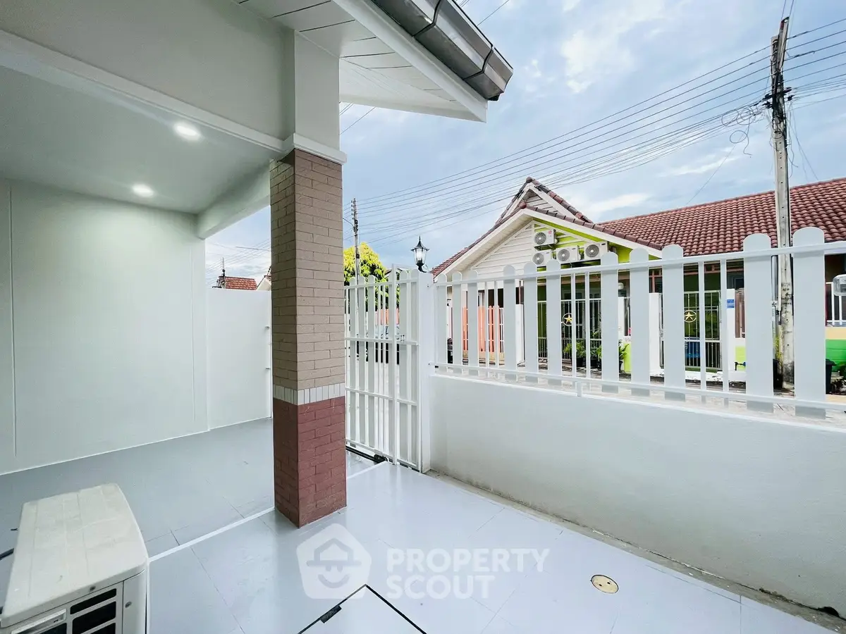 Charming residential exterior with white picket fence and covered patio area.