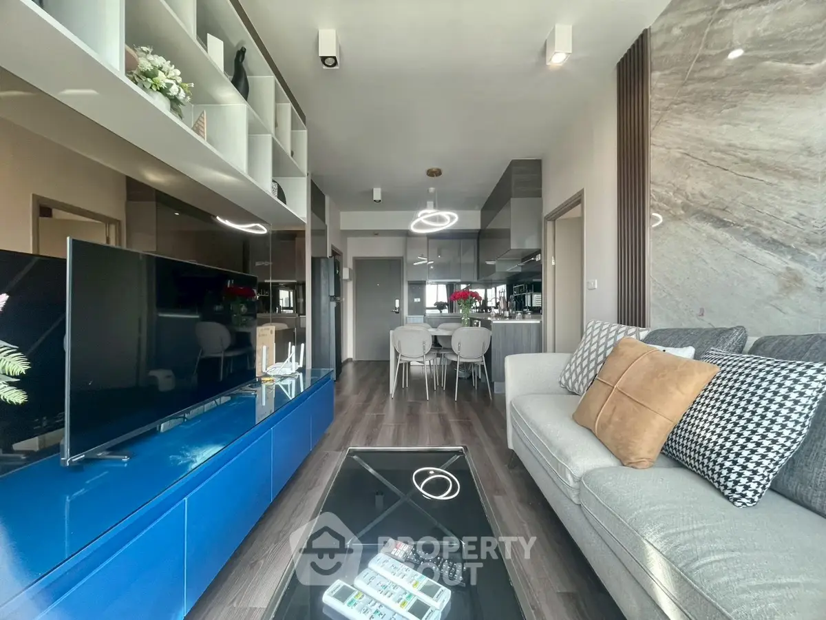 Modern living room with sleek design, open kitchen, and stylish decor in a contemporary apartment.