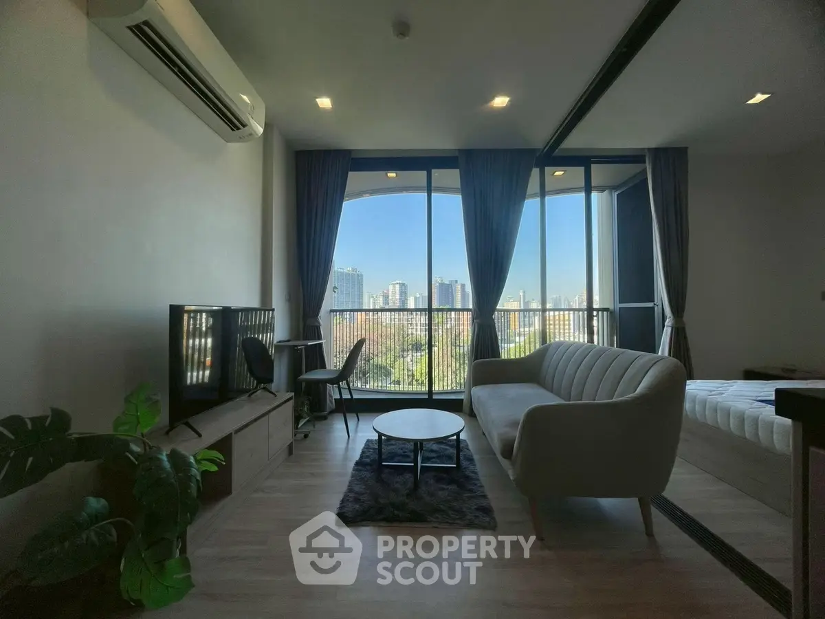 Modern living room with city view, stylish furniture, and large windows.