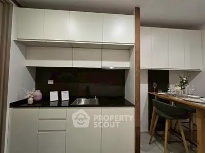 Modern kitchen with sleek cabinetry and dining area, perfect for contemporary living.