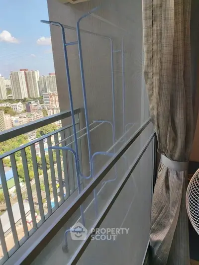 Spacious balcony with city view and drying rack, perfect for urban living.