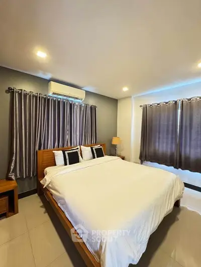 Spacious bedroom with modern decor and ample natural light