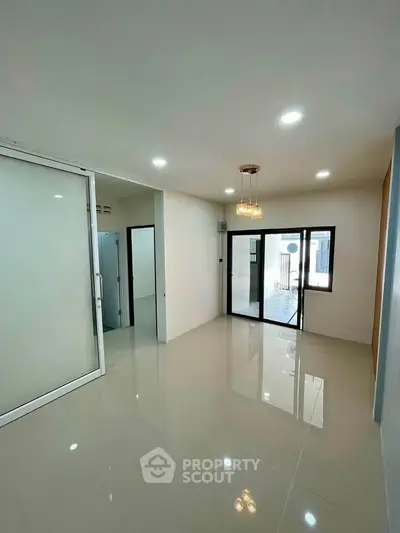 Spacious modern living room with glossy floors and elegant lighting in a contemporary home.
