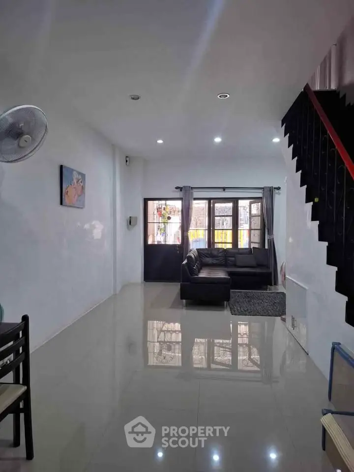 Spacious living room with modern decor and ample natural light, perfect for family gatherings.