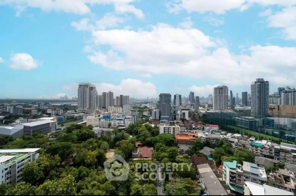 Stunning cityscape view with lush greenery and modern skyscrapers under a bright blue sky.