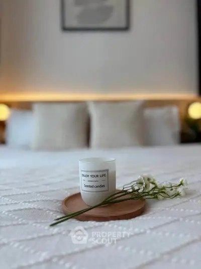 Cozy bedroom with stylish decor and scented candle on bed