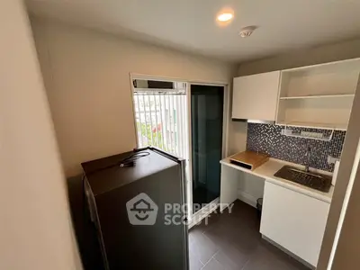 Compact kitchen with modern appliances and sliding glass door to balcony