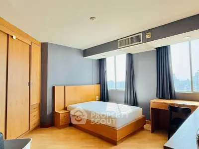 Spacious bedroom with city view, featuring wooden furniture and ample natural light.
