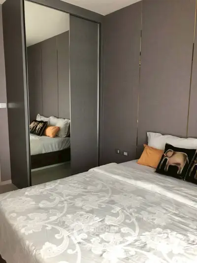 Modern bedroom with mirrored closet and stylish decor in a contemporary apartment.