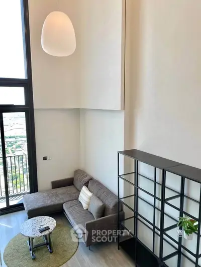 Modern living room with high ceiling and large windows offering city views