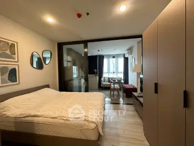 Modern studio apartment with cozy bedroom and open living area, featuring stylish decor and ample natural light.