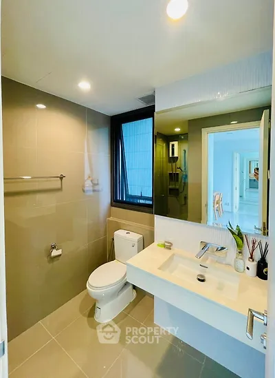 Modern bathroom with sleek fixtures and large mirror in a contemporary home.