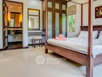 Luxurious bedroom with elegant wooden furniture and large windows offering serene garden views.