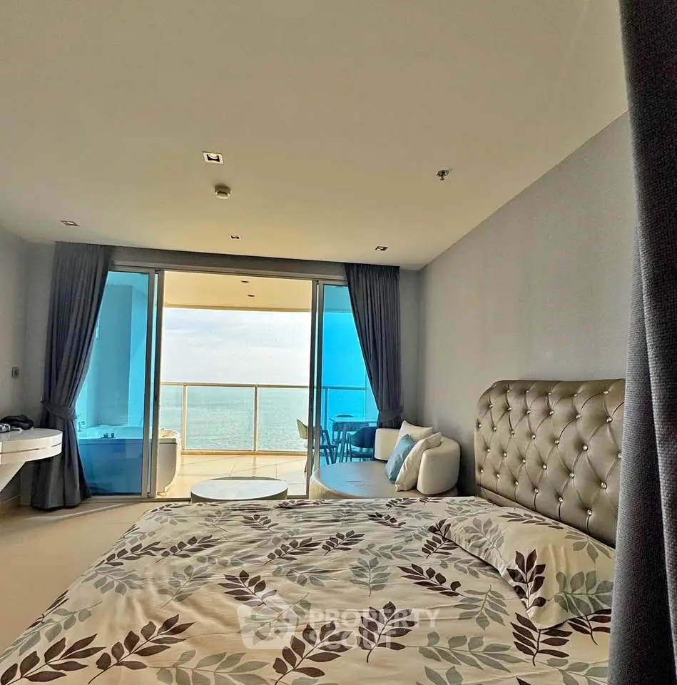 Luxurious bedroom with ocean view and spacious balcony, perfect for serene living.