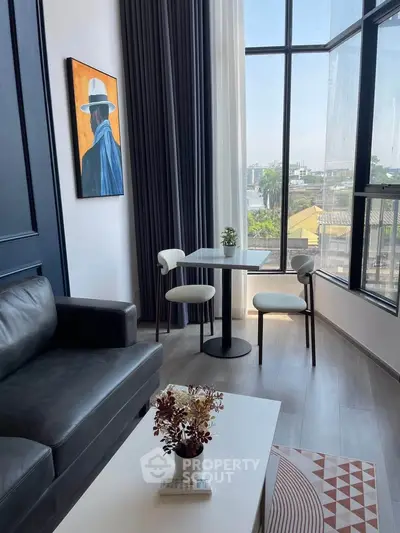 Modern living room with large windows and stylish decor in a high-rise apartment.