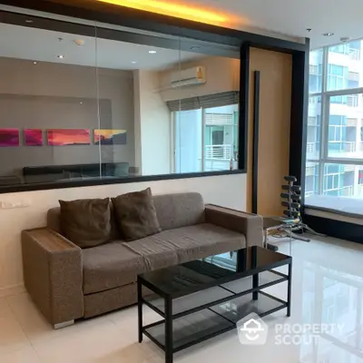 Modern living room with stylish sofa and glass coffee table in a bright apartment.