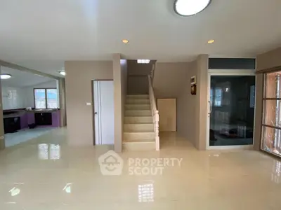 Spacious open-plan living area with modern staircase and natural light