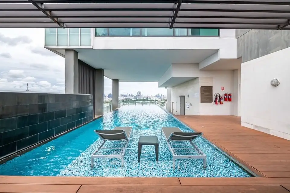 Luxurious rooftop pool with city skyline view, perfect for relaxation and leisure in a modern residential building.