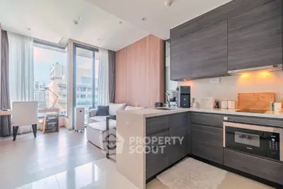 Modern open-layout kitchen and living room with city view, sleek cabinetry, and cozy seating area.