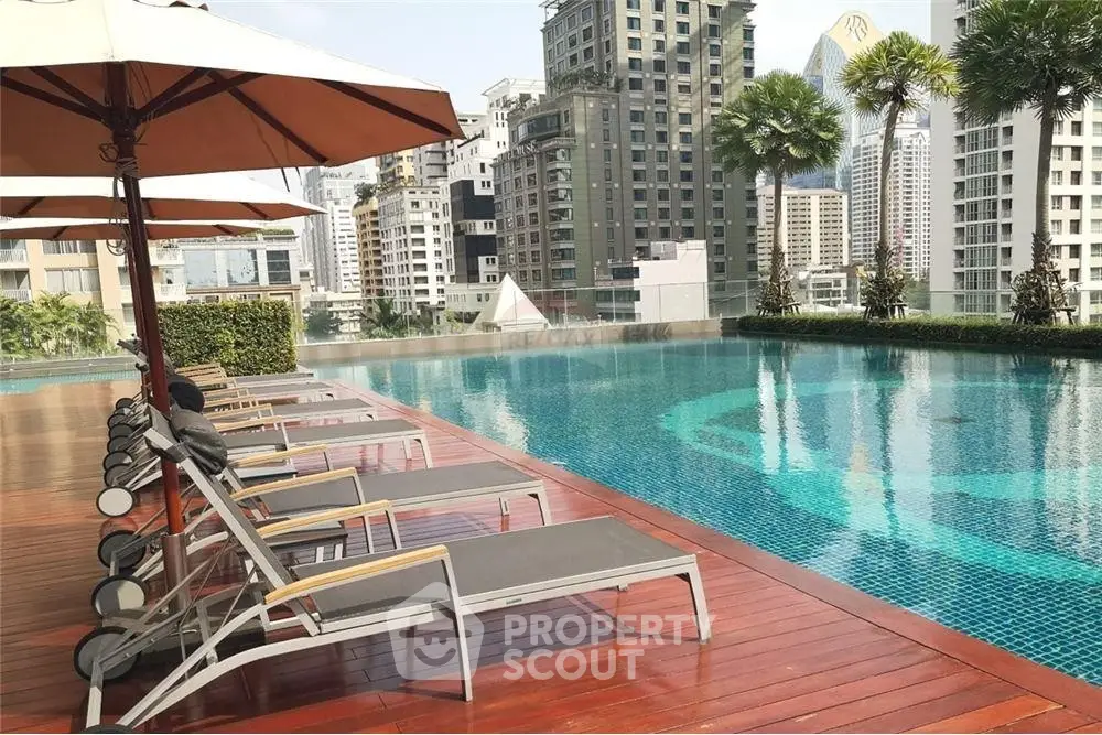 Luxurious rooftop pool with city skyline views and sun loungers in a modern urban setting.