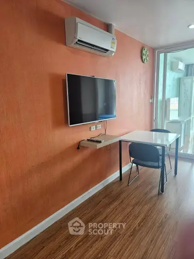 Modern study room with wall-mounted TV and air conditioning in a stylish apartment.