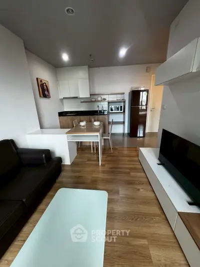 Modern open-plan living room with sleek kitchen and cozy seating area